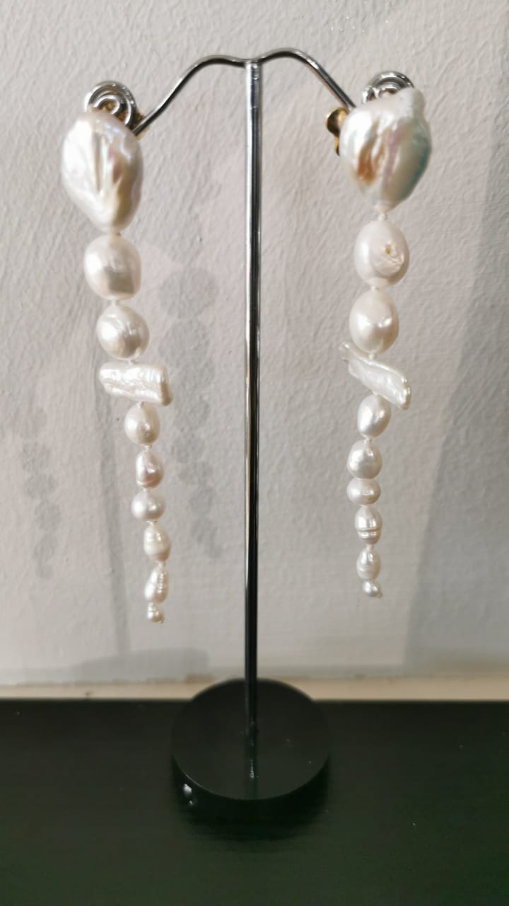 Long baroque pearl drop earrings on display stand