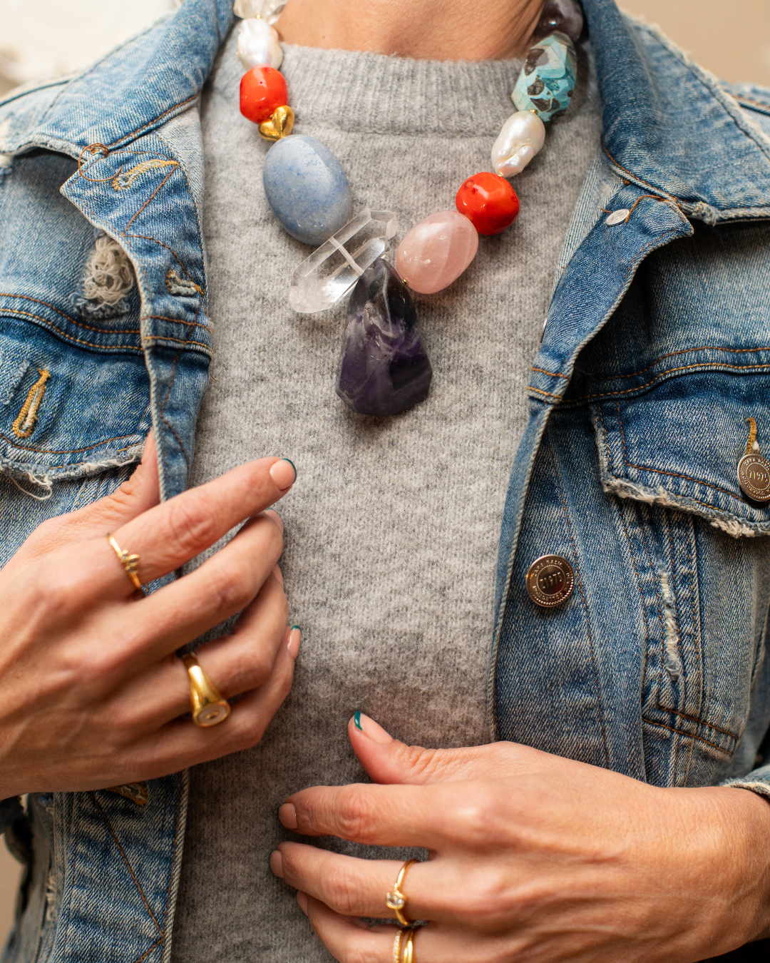Oversized multicolour gemstone statement necklace styled with a grey knit and denim jacket