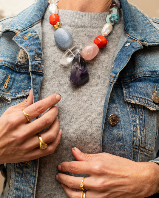 Oversized multicolour gemstone statement necklace styled with a grey knit and denim jacket
